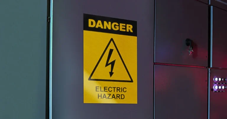 Reflective yellow electric hazard sign on a metal cabinet