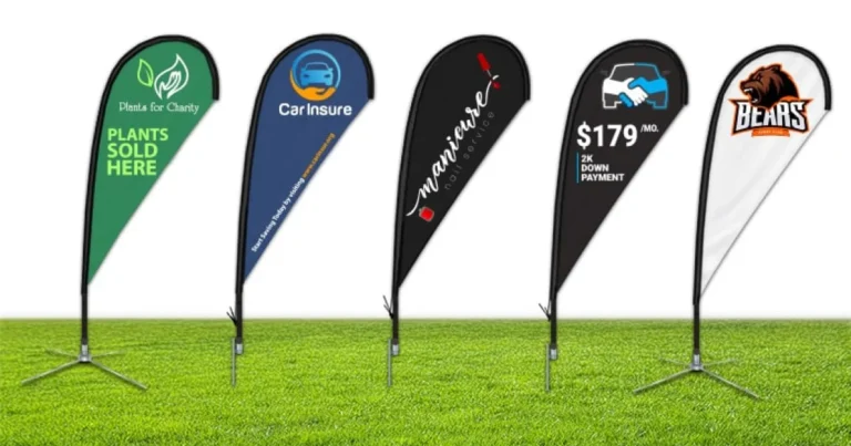 Five teardrop flags with different business designs standing on grass